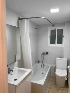 uma casa de banho com uma banheira, um WC e um lavatório. em Renovated and newly furnished 3 bedroom apartment em San Fernando