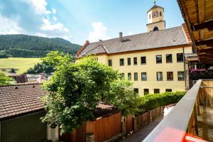 a building with a clock tower and a fence at Appartements zur Rose in Steinach am Brenner