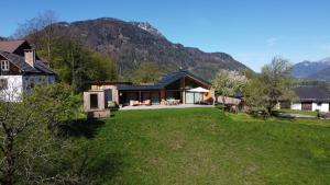 una casa en un campo con una montaña en el fondo en Haus am Salz, en Bad Ischl
