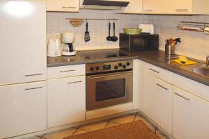 a kitchen with white cabinets and a stove top oven at Apartment, Schwerin in Schwerin