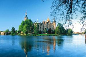 a large building sitting on the side of a lake at Apartment, Schwerin in Schwerin