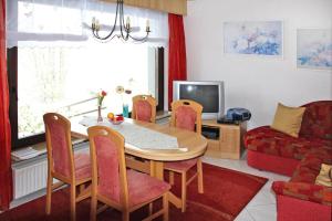 sala de estar con mesa, sillas y TV en Holiday house "Rennsteig" , Suhl, en Suhl