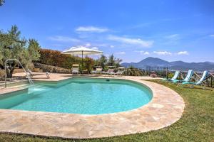 a swimming pool in a yard with chairs and an umbrella at Villa Morotti by Mmega in Montone