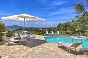 a swimming pool with chairs and an umbrella and a table at Villa Morotti by Mmega in Montone