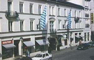 een witte auto geparkeerd voor een gebouw bij Hotel Wendelstein in Rosenheim