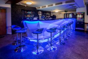 a bar with blue stools in a room at Boutique Hotel & Restaurant Bären Ringgenberg in Ringgenberg