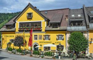 ein gelbes Gebäude mit einem Restaurant auf einer Straße in der Unterkunft Hotel Gasthof Lercher in Murau