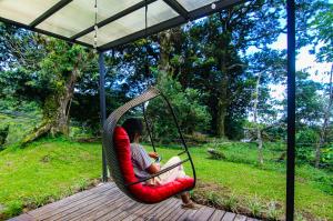 a person sitting in a hammock with a laptop at Mar Inn Costa Rica in Monteverde Costa Rica