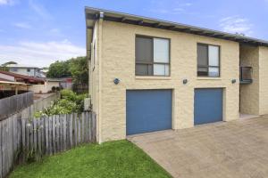 a house with two garage doors in a yard at William St 1 70 Moffat Beach in Caloundra