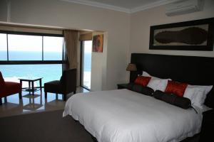 a bedroom with a bed and a view of the ocean at Simon’s Town Guest House in Simonʼs Town