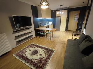 a living room with a couch and a table at Apartamenty Wola in Warsaw