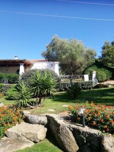 un jardin fleuri et un chemin en pierre dans l'établissement Sardinia Family Villas - Villa Gaia with private pool in the countryside, à Sant Antonio Di Gallura