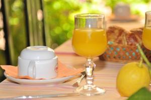 a table topped with a plate of food and a glass of orange juice at Hôtel Narev's in Menton