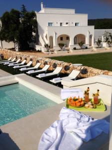 a tray of fruit sitting on a table next to a swimming pool at Masseria Corte degli Asini in Montalbano