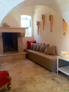 a living room with a couch and a fireplace at Masseria Corte degli Asini in Montalbano