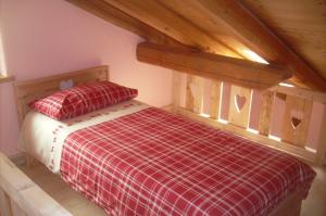 a bedroom with a bed with a red and white blanket at La Ferme du Grand Paradis in Cogne