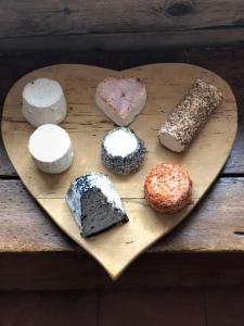 a heart shaped cutting board with different types of cakes at La Ferme du Grand Paradis in Cogne