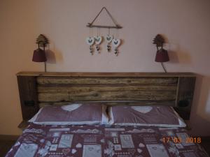 een slaapkamer met een houten bed met 2 verlichting aan de muur bij La Ferme du Grand Paradis in Cogne