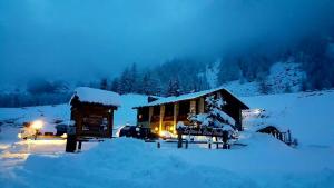 una cabaña cubierta de nieve en una montaña nevada en La Ferme du Grand Paradis, en Cogne