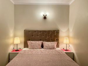 a bedroom with a bed with two lamps on both sides at Milne Apartments in Saint Petersburg