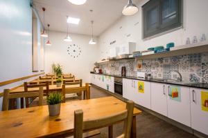 un restaurante con mesas y sillas de madera y una cocina en 360 Hostel Borne, en Barcelona