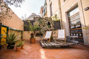 360 Hostel Borne في برشلونة: كرسيين جالسين على فناء بالنباتات