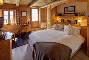 a bedroom with a large white bed in a room at La Ferme du Chozal, Chalet de tradition in Hauteluce