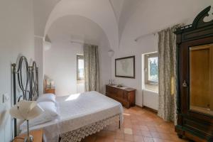 um quarto com uma cama, uma cómoda e janelas em Masseria Casina Baronale em Serrano