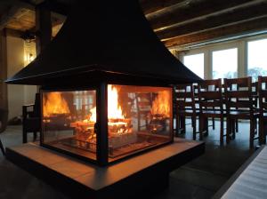 una chimenea en un comedor con chimenea en Palaima Hotel Anykščiai en Anykščiai