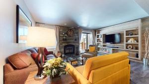 a living room with a couch and a table with a lamp at Mammoth Creek #9 condo in Mammoth Lakes
