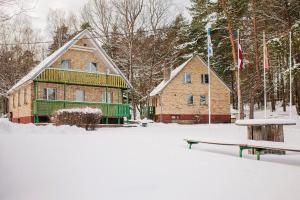 a house in the snow with a bench and flags at LAKE HOUSE in Riga