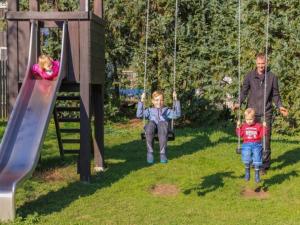 Wittelshofen的住宿－Ferienbauernhof Moarhof，两个孩子和一个男子在摆摆摆架子上玩耍