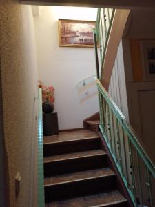 uma escadaria com degraus de madeira e uma pintura na parede em Ferienwohnung am Wasserturm em Hohen Neuendorf