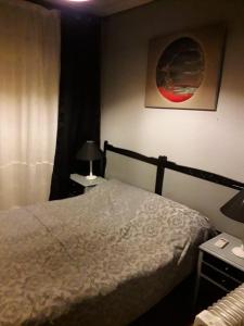 sypialnia z łóżkiem, 2 stołami i lampką w obiekcie Bonito piso en Puerto de Sagunto w mieście Puerto de Sagunto