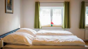 un letto con due cuscini di fronte a una finestra di Ferienwohnung Trendelmühle Lautrach a Lautrach