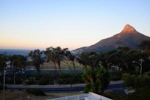 una montagna in lontananza con una strada e alberi di Camps Bay Loft with Stunning Mountain and Ocean Views a Città del Capo