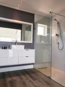 开普敦Camps Bay Loft with Stunning Mountain and Ocean Views的带水槽和玻璃淋浴间的浴室