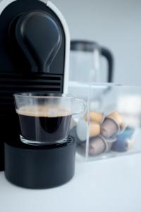 a black coffee maker with a cup of coffee at Camps Bay Loft with Stunning Mountain and Ocean Views in Cape Town