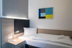Postel nebo postele na pokoji v ubytování Alpha & Omega Hotel