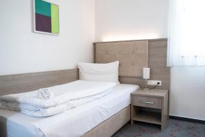 Postel nebo postele na pokoji v ubytování Alpha & Omega Hotel