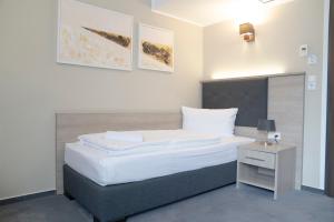 Postel nebo postele na pokoji v ubytování Alpha & Omega Hotel