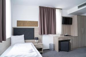 Postel nebo postele na pokoji v ubytování Alpha & Omega Hotel