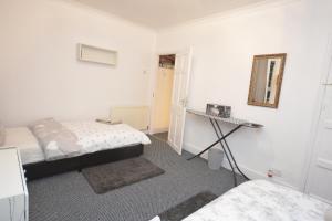 a bedroom with two beds and a mirror on the wall at Lovely 3 Bedroom House near Barking Station in Barking +13 photos