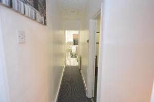 um corredor com uma parede branca e um corredor com uma porta em Lovely 3 Bedroom House near Barking Station em Barking