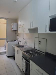 cocina con fogones y fregadero en Departamento de estreno en 1er piso en Condominio, en Piura