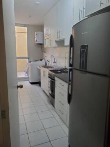 eine Küche mit einem Kühlschrank aus Edelstahl und weißen Schränken in der Unterkunft Departamento de estreno en 1er piso en Condominio in Piura