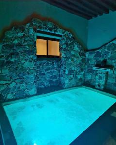 a pool in a room with a stone wall at Hotel Spa Casa del Sol in Guanajuato