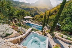 bañera de hidromasaje al aire libre con vistas a la montaña en MarcheAmore - La Roccaccia relax, art & nature, en Montefortino