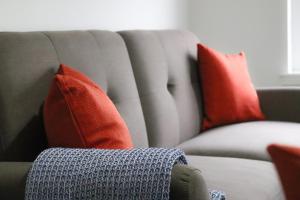 Jackson Apartment في كوتبريدج: أريكة عليها وسائد حمراء وبرتقالية