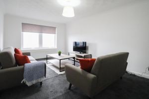 a living room with two couches and a tv at Jackson Apartment in Coatbridge